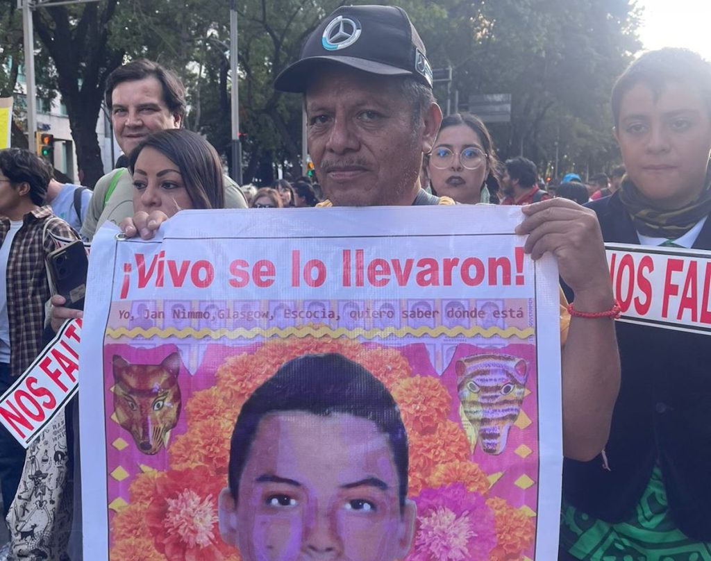 Clemente Rodríguez sostiene el retrato de su hijo en la marcha del 26 de septiembre.