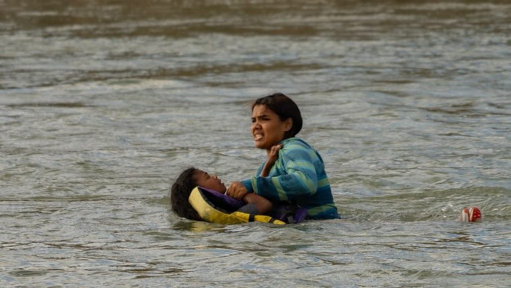 Una mujer migrante cruza el río Bravo junto a su hija en 2023.