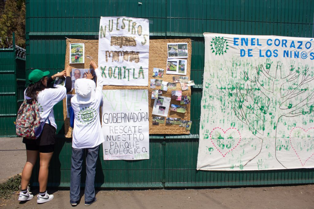 Manifestantes colocan carteles de protesta sobre la malla ciclónica que protege la entrada del parque Xochitla.